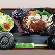 煮え立つソースの香りがたまらないボリュームたっぷりのハンバーグ。熱々の鉄板をお席までお届けします。