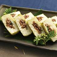 ポルトガル語で小舟を意味するバッテイラ。

甘辛く味付けされた近江牛を挟み込むようにして押し寿司に仕上げました。
近江牛と大葉が味のアクセントとなり、松喜屋オリジナルの一品です。
