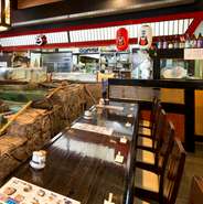 お店の中央にある大きないけすの前には、一人で座ることができるカウンター席があります。少人数でもいけすで元気に泳ぐ魚介類を見ながら、その日によって異なる、新鮮な素材を味わうことができます。