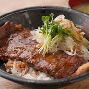 ご好評いただいている『国産黒毛和牛サーロインステーキB』と同じサーロインを1枚全て使います。上質な肉を、普段使いのお値段で味わえる一皿です。味付けは、丼ものですので、ご飯に合うように整えています。