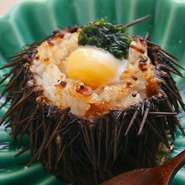 北海道産のムラサキウニの殻に、ご飯とウニを乗せてオーブンで焼き上げました。さらに、半熟のうずらの玉子と生のりをトッピング。磯の香りとウニの濃厚な味わいが口の中いっぱいに広がり、思わず笑顔がこぼれます。