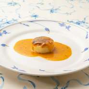 ホタテ貝のすり身と生クリーム、卵を合わせ、オーブンでふんわりと焼き上げられた一品。殻まで丸ごと使われた甘海老のソースは、香りが際立ち食欲がそそられます。海老の甘みが溶け込んだソースは絶品の味わいです。