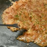 看板メニューの『もんじゃ焼き』と『お好み焼き』は、東京下町の文化を感じさせる味わい。本場・月島で修業した職人がつくるソースとだしにこだわっています。選べるトッピングで自分好みの1枚を楽しんではいかが。