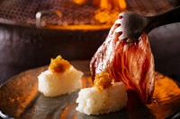 スタッフが絶妙な焼き加減で提供する人気のトロカルビの炙り寿司をお楽しみください。