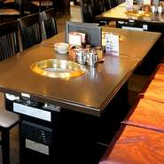 テーブル席はひろびろとしていて清潔。埋め込み式のコンロが設置されています。お皿を何枚も置いてお肉を焼くことができるゆったり空間で、極上の食材をお好みに焼き上げることができるのが魅力です。