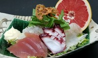 お魚が乗ったサラダにグレープフルーツを絞る斬新さ
