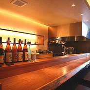 一枚板の重厚感あるカウンターにゆったりくつろいで座れるローチェアー。時を忘れて楽しめる空間。