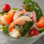 ベビーリーフ、水菜、スライス玉ねぎといった野菜とスモークサーモン、蒸しエビなどの海鮮を合わせ、自家製の玉ねぎドレッシングでお召し上がりいただきます。夏の時期にぴったりの季節限定メニューです。