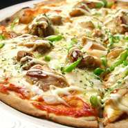 お店でしっかり作っている人気の本格手作りピザ。唐辛子とサラミがのっていて、ピリ辛な味付けのこのピザはビールとの相性抜群で、ライブを愉しみながらご堪能いただけます。