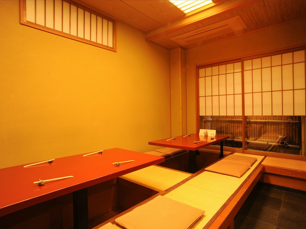 雪見障子風のしつらえ越しに坪庭が見える