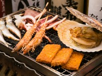 ほたて、車海老、ししゃも、がんす、いか一夜干しを自分で炙るスタイルです。シンプルな調理法ながら素材の持ち味を堪能できると好評です。目の前のコンロで焼いてアツアツの海鮮に舌鼓。