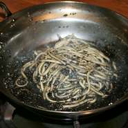 もつ鍋の残りスープにちゃんぽん麺を投入、ごまをたっぷり混ぜて完成。スタッフが調理してくれます。