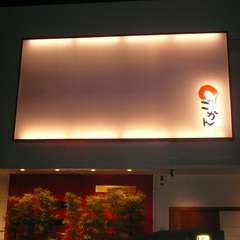 アール型の壁に灯が灯り、目にはおどろく大きな看板と坪庭