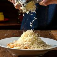ミートパスタの上から豪快にラクレットチーズを生削り♪濃厚ラクレットチーズと絡み合う極上パスタをどうぞ！