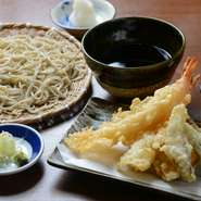プリプリのエビ2本と野菜3種類の天ぷらがのった冷たいそば。揚げたての天ぷらをつゆや塩で味わえます。