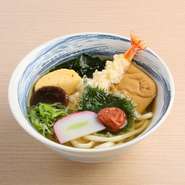 海老天やきつねなど8品の食材を贅沢にのせた彩り豊かなうどんです。注文に迷って、アレも食べたい！コレも食べたい！と一度にいろいろなものを楽しみたい人におすすめです。