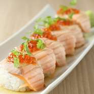 定番メニューを始め、お客様が驚くような意外性のある料理、さらには季節限定料理などをつくります。さらに、『炙りサーモンとイクラの親子ロール寿司』のような、少し遊び心を加えたメニューも忘れません。