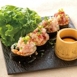 ごま油で風味付けしたご飯と具材を海苔で巻き、ネギトロを贅沢に乗せました。卵黄ダレをたっぷり絡めてどうぞ。