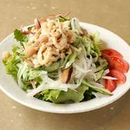 噛むほどに親鶏特有のしっかりとした旨味と食感の種鶏皮とお野菜をピリッと辛い濃厚な胡麻風味に仕上げたバンバンジーサラダです。　ハーフサイズ400円
