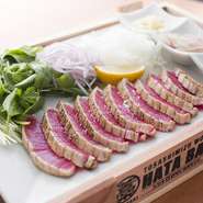 現地でないとなかなか食べられない「土佐まぐろ　ハラボ」。藁で香ばしくたたきにしました。シンプルに塩で焼いているので、付け合わせの自家製ビネガーやガーリックオイルなどで食べ比べてみましょう。