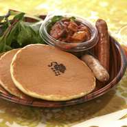 雑穀パンケーキと6種の野菜のトマト煮。2種のソーセージと温泉卵を添えて。※ジュース付き