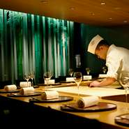 和の伝統と現代的な美意識が融和する非日常の世界。
広々としたカウンター越しには匠の腕をもつ料理人たちが
日本各地から選りすぐった食材で、入魂の一皿を描き出していきます。