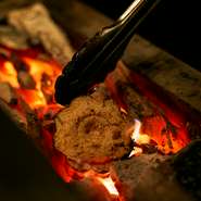 薪の香ばしい香り漂うカウンター前で炭火焼きを堪能