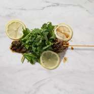 ベトナムで人気の甘辛タレ・ヌクチャムでマリネした希少部位の米国産ラウンドオイスターを香ばしく焼き上げ、たっぷりのフレッシュパクチー＆レモンをのせて仕上げた串焼き。