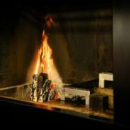 かねてよりやりたいと思っていた薪火の料理。「火も素材のひとつ」という考えで、この程導入に至りました。温度の低い、柔らかい火で肉をしっとりと焼き上げます。
