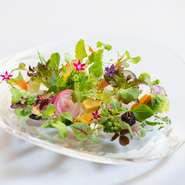 野菜の料理に使用するのは流麗な曲線のガラス皿