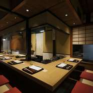 店主の作業を見ながら、ゆったりと食事が楽しめる掘りごたつのカウンター席。重厚な天板は十分な奥行きがあり、大皿が置かれても圧迫感はありません。