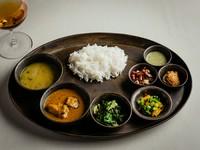 ネパールの定食“ダルバート”も丁寧な下ごしらえが伝わる優しいおいしさ。お決まりの豆スープと白飯にナマズのカレー。青菜炒めの他、発酵乾燥高菜のグルンドックと大根等のアチャールが味わいに彩りを添える。