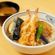 見るからにころもサクサクの海老、元気のいい旬の野菜、玉子を割ればトロッとした黄身、タレの染み込んだご飯……天ぷら専門店の天丼は、それぞれの味わいとともに、揚げたての醍醐味は何よりのおいしさ。