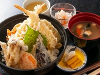 丼からはみ出すほどの大きな海老天2つに、季節の野菜の天ぷらが6つ、合計8つも天ぷらがのった、ボリューム満点の『天丼』。鰹だしと醤油をベースにした特製のタレが、天ぷらとごはんの旨さをより引き立てます。