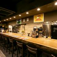 お店に入ると大きな一枚板のカウンターがお出迎え。調理過程を見ながらお食事がたのしめます。また、調理が落ち着いたら店主との会話もぜひ。