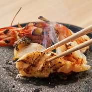 熱した富士山の溶岩石で鮑などの魚介を焼いて召し上がっていただく石焼き料理は 卓上で焼く工程も楽しめる料理です
食材の表面だけを香ばしく焼き 磯の風味と素材それぞれの食感をお楽しみください