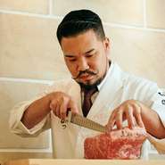 ゲストの目の前で料理を行う料理人は、一つ一つの食材のこだわりや魅せ方、おいしさなどを熟知しています。流れるような所作で肉を捌き始めていく姿に、人々の目は釘付け。