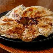 ジュ～っという音が食欲をそそる一品。お客様の「餃子が食べたい」という一言から、この商品が誕生！今では、当店人気の一品に。噛んだ瞬間、トリュフ、ポルチーニ茸の香りや風味が口の中でふわ～っと広がります。