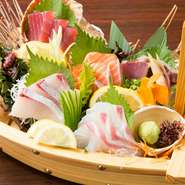 豪華な舟盛りで提供される刺身の盛り合わせ。その時々の新鮮な地魚が彩りよく盛り付けられており、目にも鮮やかな逸品です。テーブルをより華やかにしてくれるので、祝いの席などにも適しています。