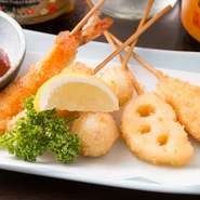 揚げたて熱々の串カツは、サクッと軽やかな食感を楽しめます。衣が薄く、素材の旨みや地味深さをしっかり感じられ、ビールのお供にぴったり。盛り合わせだけでなく、単品注文（1人前2本）もできます。
