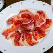 薄目にカットすることで口の中で豊潤な豚の脂が溶け、香ばしい風味へと昇華。切り立ての新鮮な味わいがワインのおいしさをグンと引き立てます。