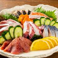 市場直送の新鮮な魚介を刺身の盛り合わせで提供！　5～6点盛りで、マグロやサーモン、蛸といった定番ネタから、岡山名物のサワラのタタキも付いて人気。少し甘めのオリジナル醤油が素材の味を引き立てます。