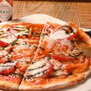 店内で手づくりのピザ生地は、カリカリとしたクリスピーのような食感ともっちりとしたやわらかさが特徴です。甘さと酸味が絶妙な自家製トマトソースとチーズのハーモニーも絶品です。
