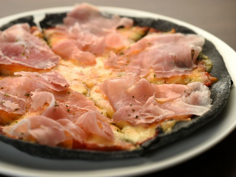 イカスミ入りの黒い生地がインパクト大! 人気の『生ハムピザ イカスミ入り黒い生地』