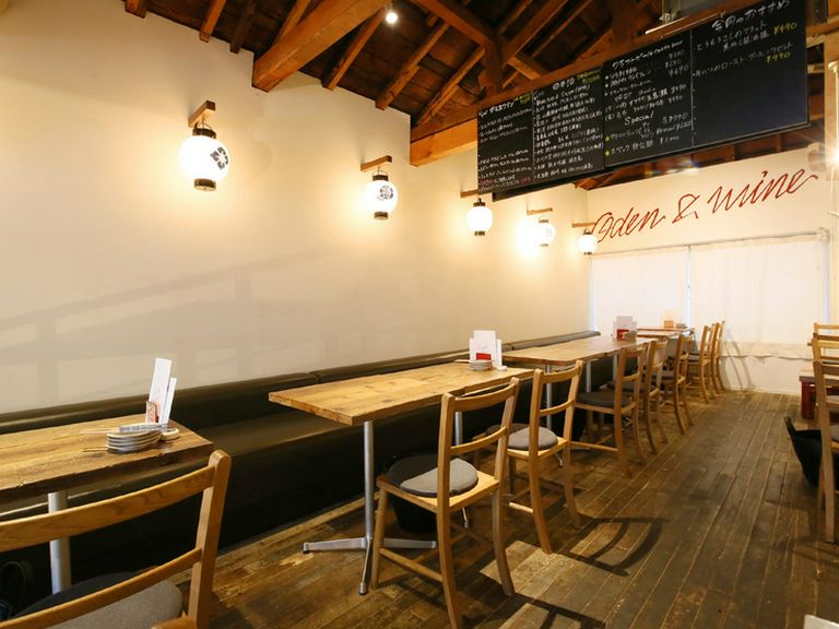 天井が高く木の風合いと白い壁に壁の提灯がオシャレな店内