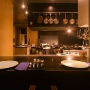 メインダイニングはオープンキッチンに面し、調理の臨場感を楽しめる設え。テーブル席に加え、カウンター席で肩を並べて憩うのもすてき。素材を見て好きな肉を選べる「食材プレゼン」など、粋な演出も楽しめます。