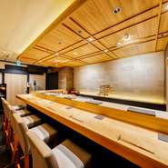 舞台のように臨場感を楽しんでほしいという思いで設えられたカウンター。パフォーマンスに見立てられたコースを、肩肘を張らず心穏やかに味わうことができる寿司店です。