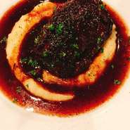 たっぷりと赤ワイン ポートワイン フルーツヴィネガー ブランデーを使い、香味野菜とマリネした牛のほほ肉を8時間煮込みます。旬の野菜やマッシュポテトが付け合わせ。