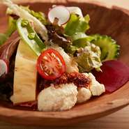 島らっきょの天ぷらやゴーヤなど旬の沖縄野菜と、沖縄名物 “ゆし豆腐” のサラダ。昔ながらの自釜で仕上げる "ゆし豆腐" と自家製の “食べるカリカリ辣油” は病みつきになる美味しさ。
