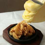 ラクレットとは、チーズの切り口を温めて、中がとろりとなったところを削いで具材にかけて食べるスイスの伝統的なチーズ料理。